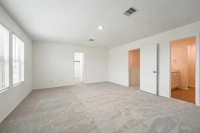 an empty room with windows and closet