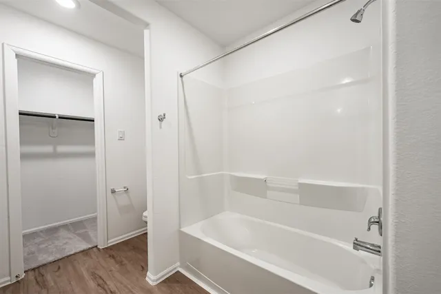 a white bath tub sitting next to a shower