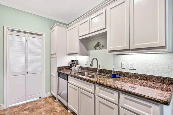 a kitchen with stainless steel appliances granite countertop a sink and a white cabinets