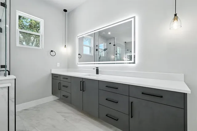 a bathroom with a double vanity sink a mirror and bathtub