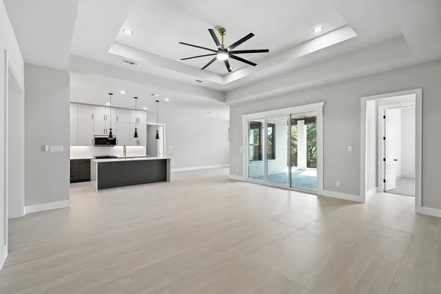 a view of an empty room with cabinet and a ceiling fan