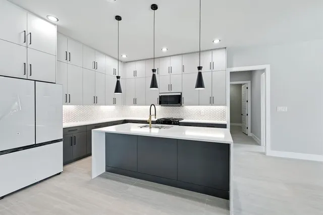 a large kitchen with a sink and refrigerator