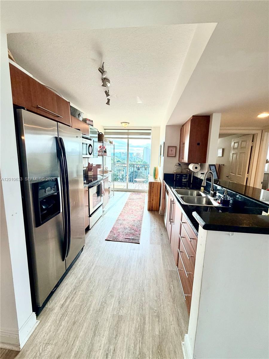 3232 Southwest 22nd Terrace, Unit 910 Miami, FL 33145 - Photo 10 of 31 a kitchen with stainless steel appliances a refrigerator a sink a stove a washer dryer and appliances