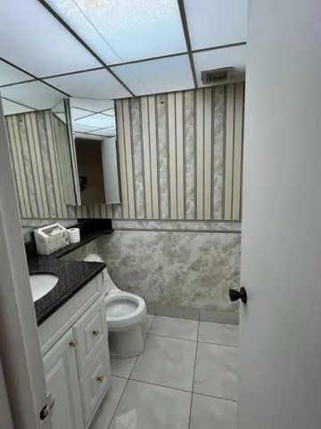 a bathroom with a granite countertop sink a toilet and a shower