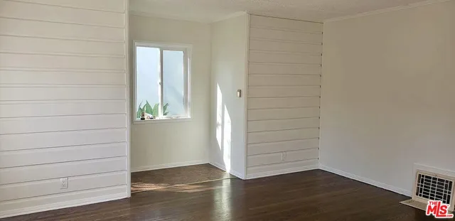 a view of wooden floor and windows in the room