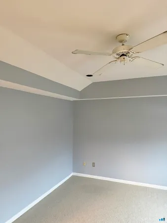 an empty room with a ceiling fan and a window