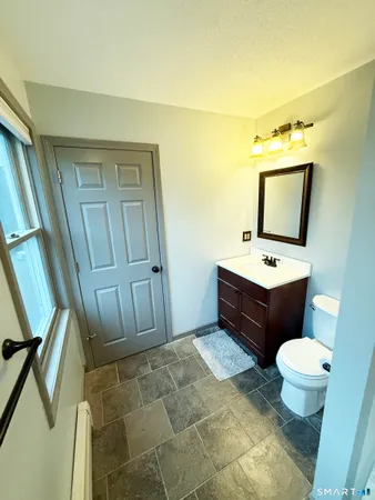 a bathroom with a toilet sink and mirror