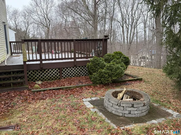 a view of a wooden house with a yard and wooden fence