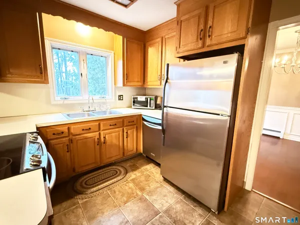 a kitchen with a refrigerator a stove a sink and a window