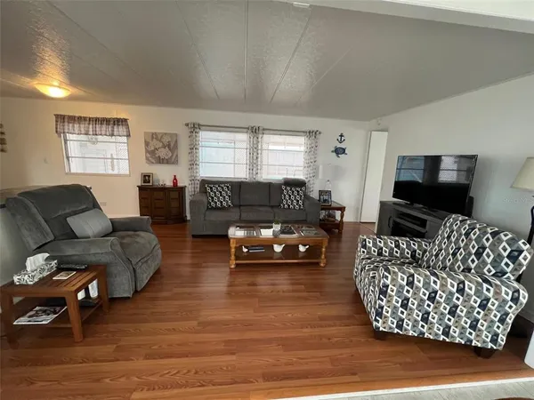 a living room with furniture a flat screen tv and a window