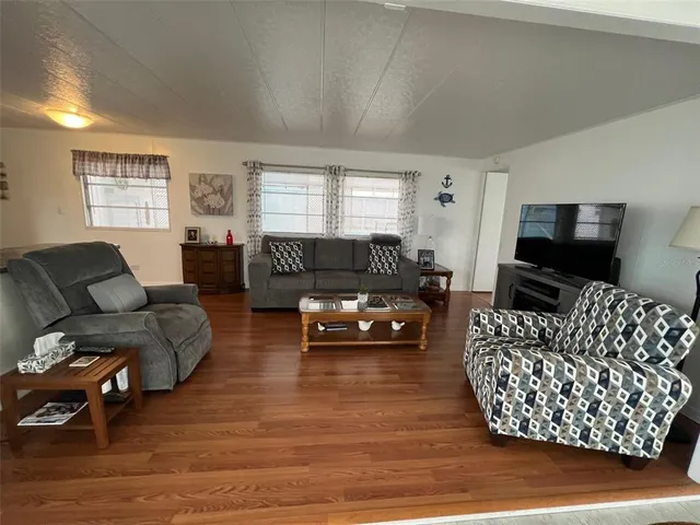 a living room with furniture a flat screen tv and a window