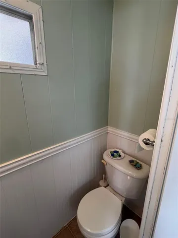 a white toilet sitting next to a small window