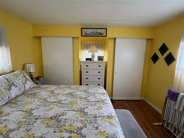 a bedroom with a bed and wooden floor