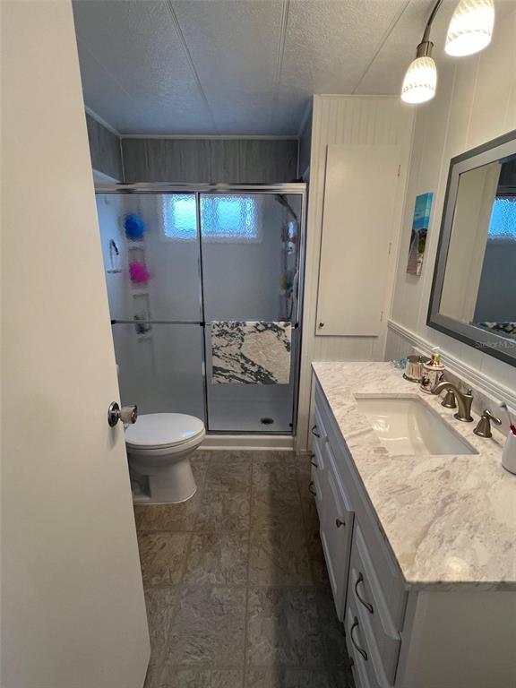 44 Thatch Palm Street West Largo, FL 33770 - Photo 20 of 25 a bathroom with a granite countertop sink a toilet and shower