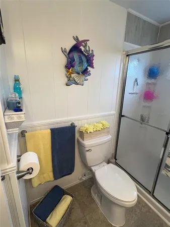 a white toilet sitting next to a bathroom sink and a tub