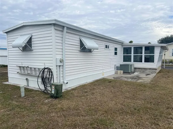 a view of a house with a patio and a yard