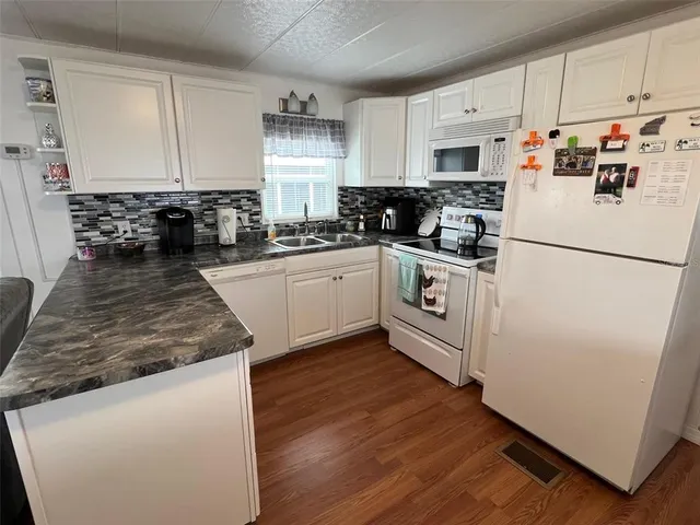 a kitchen with white cabinets and white appliances