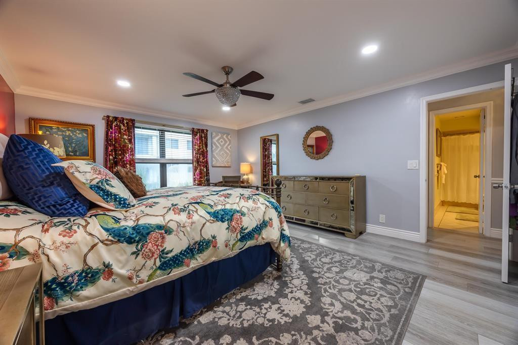 201 Southwest 1st Street, Unit 10 Boca Raton, FL 33432 - Photo 16 of 28 a bedroom with a bed a dresser and wooden floor