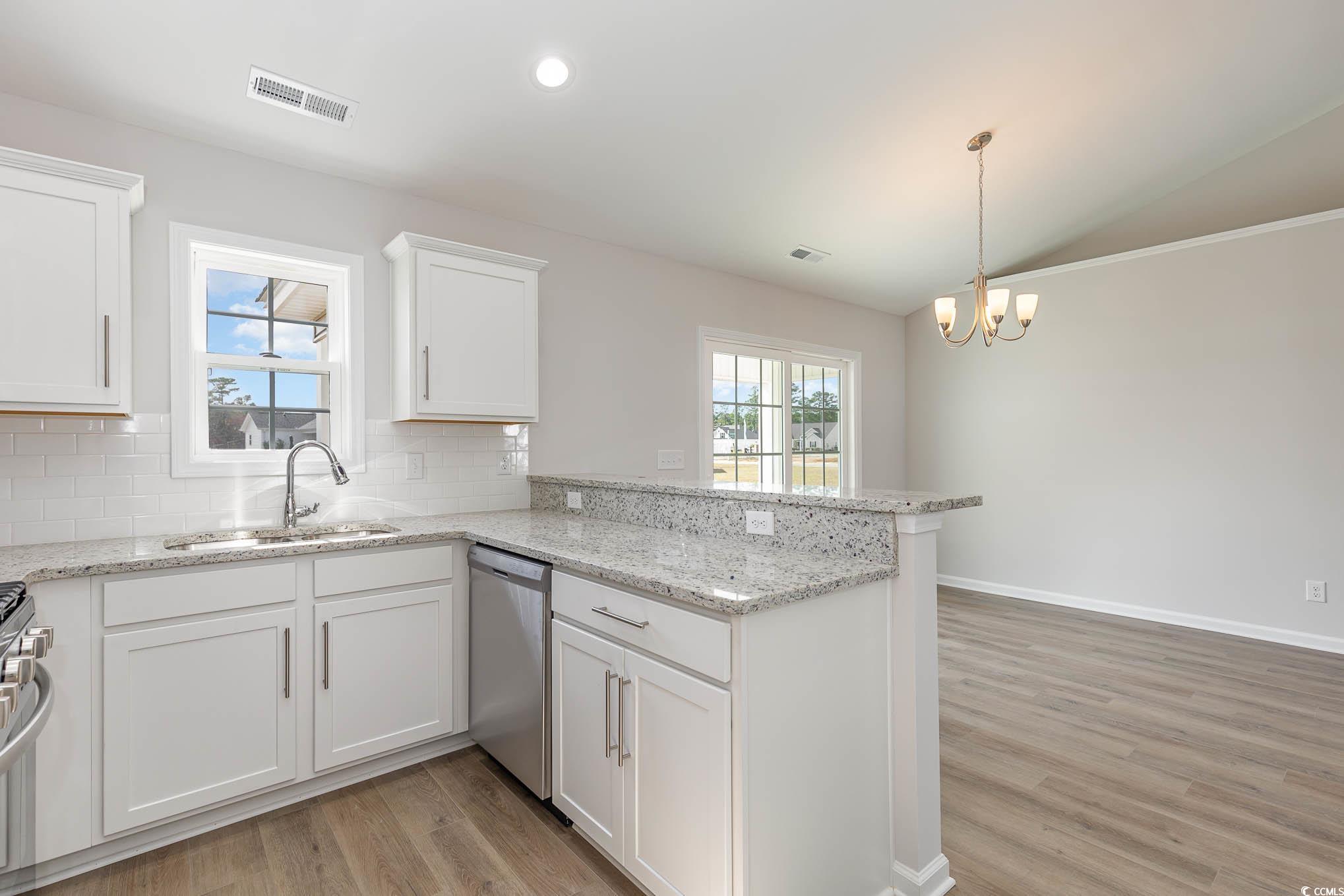 355 5th Avenue Aynor, SC 29511 - Photo 6 of 15 Kitchen with a peninsula, white cabinets, light wood-style floors, light stone counters, and lofted ceiling