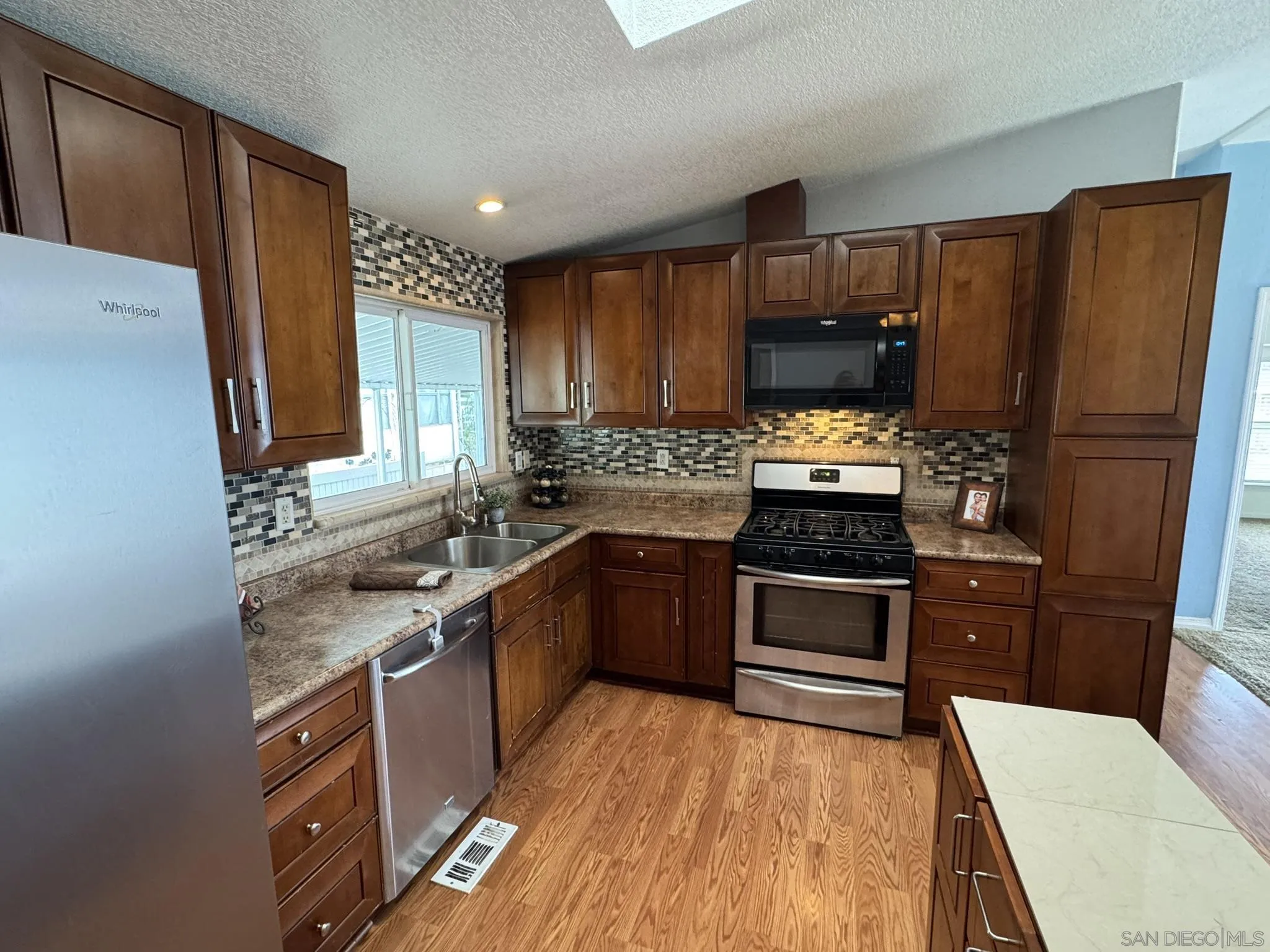 3505 Alpine Boulevard, Unit 66 Alpine, CA 91901 - Photo 3 of 22 a kitchen with stainless steel appliances granite countertop a stove refrigerator sink and dishwasher