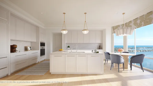 a view of a kitchen with kitchen island a large counter space a sink stainless steel appliances and cabinets