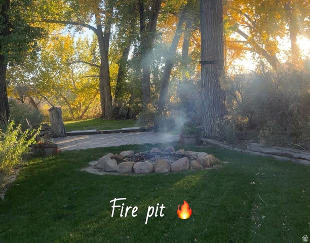 2815 Gordon Creek Road Price, UT 84501 - Photo 12 of 13 Outdoor fire pit featuring a natural stone surround and a manicured lawn