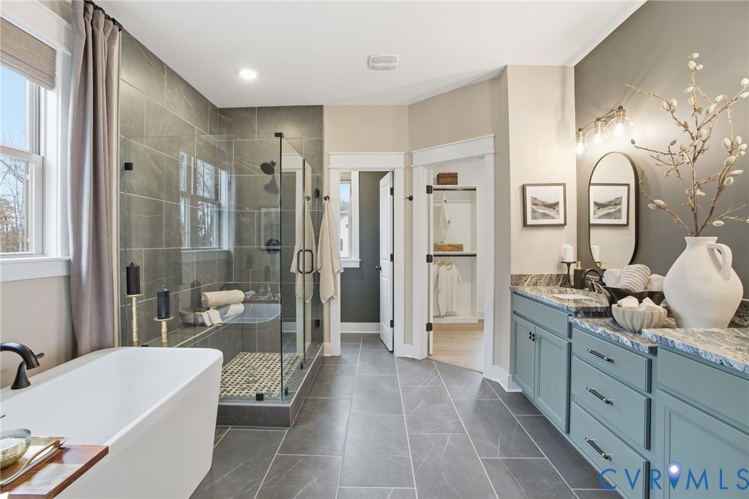 4023 Tuckmar Ridge Drive Moseley, VA 23120 - Photo 4 of 21 a spacious bathroom with a double vanity sink a large mirror a shower and bathtub