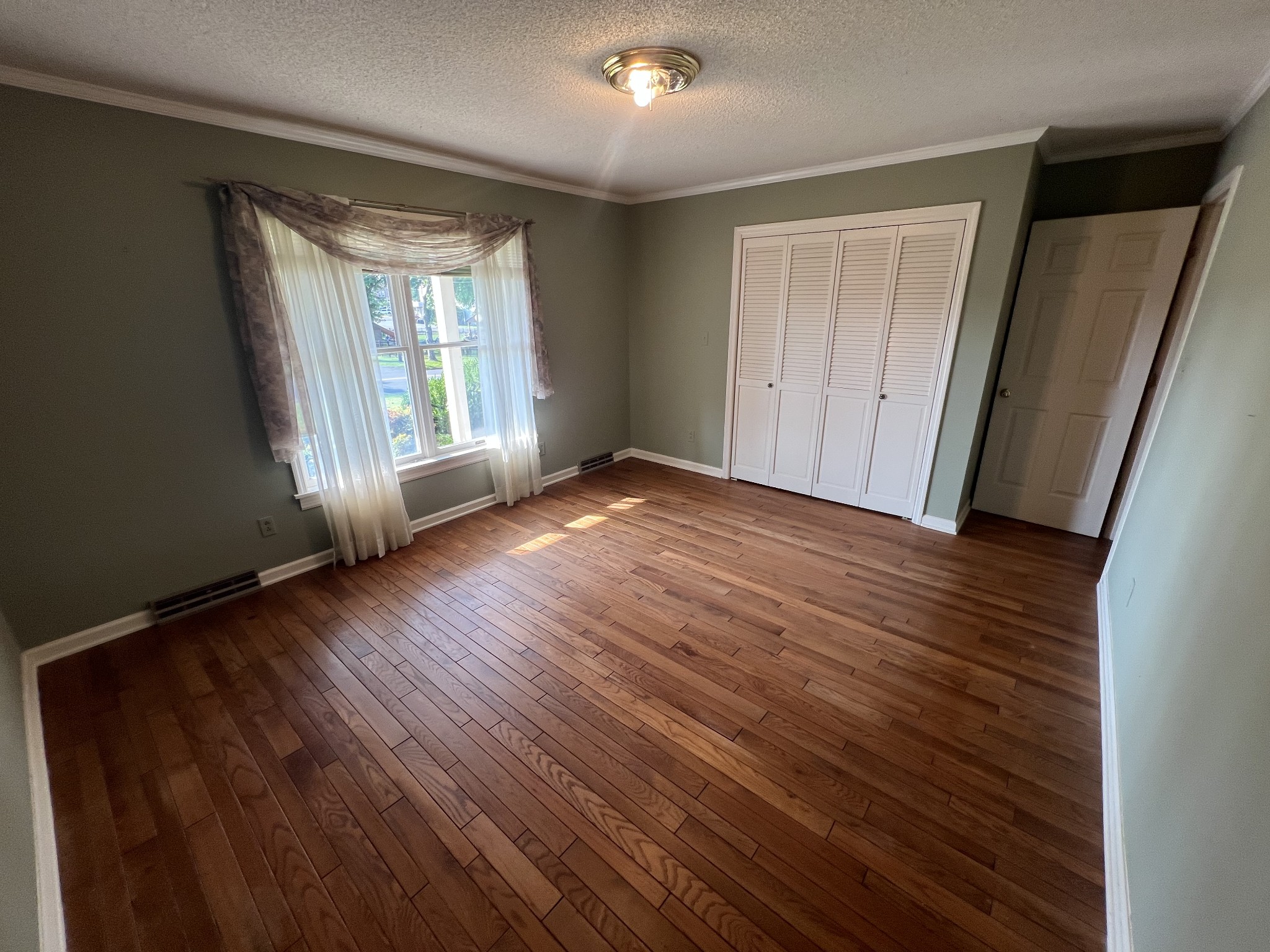 212 North 3rd Street Pulaski, TN 38478 - Photo 18 of 38 a view of an empty room with wooden floor and a window
