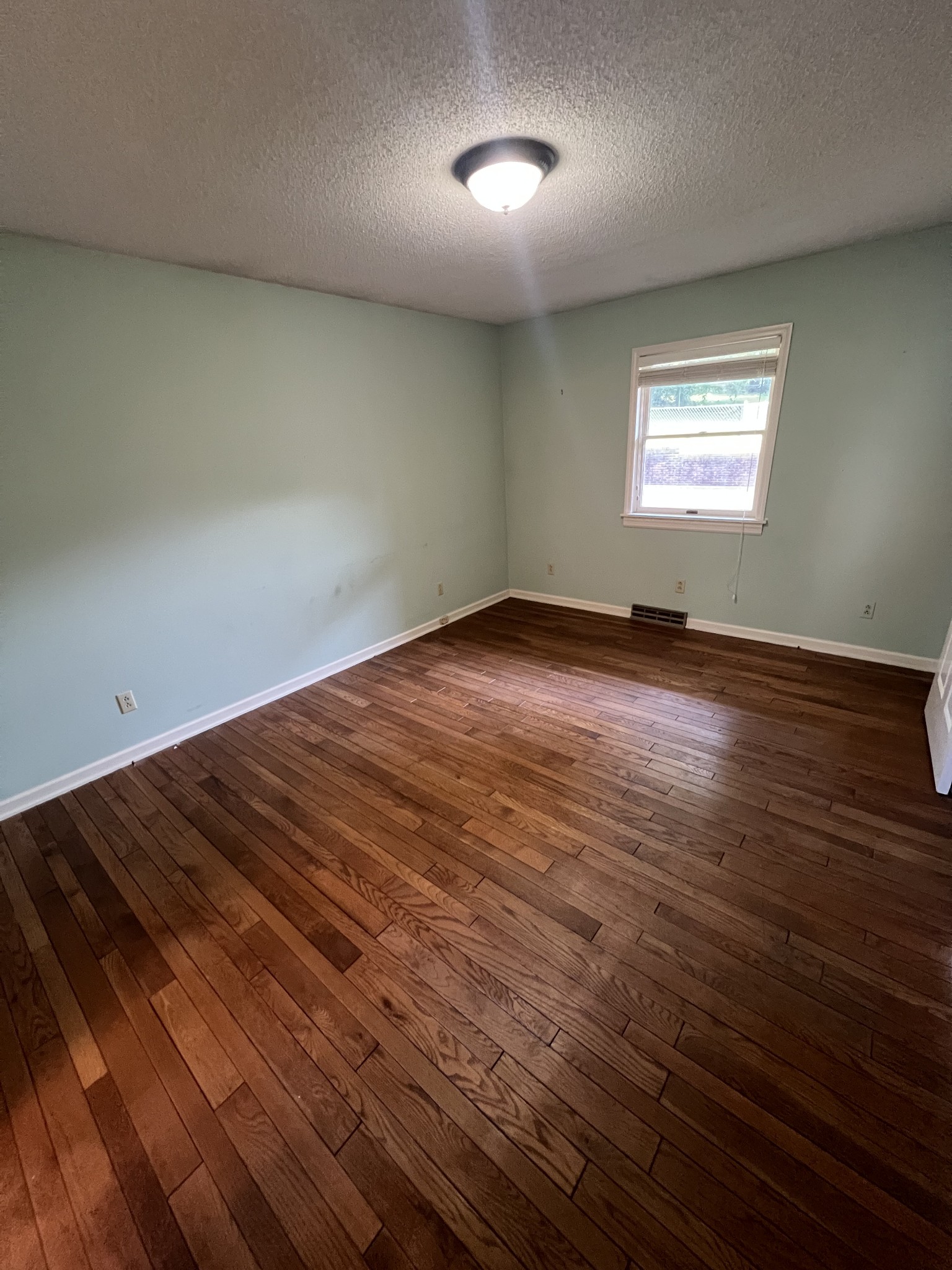 212 North 3rd Street Pulaski, TN 38478 - Photo 28 of 38 an empty room with wooden floor and windows