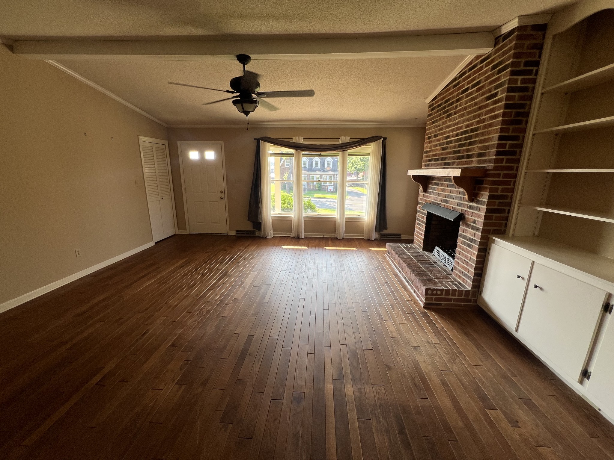 212 North 3rd Street Pulaski, TN 38478 - Photo 8 of 38 a view of an empty room with wooden floor fireplace and a window