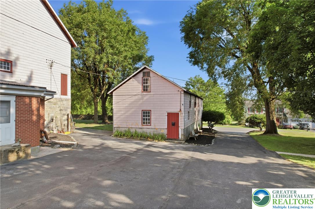 4682 Steuben Road Bethlehem, PA 18020 - Photo 51 of 79 A classic barn, with a striking red door, nestled amidst lush trees and a paved drive.