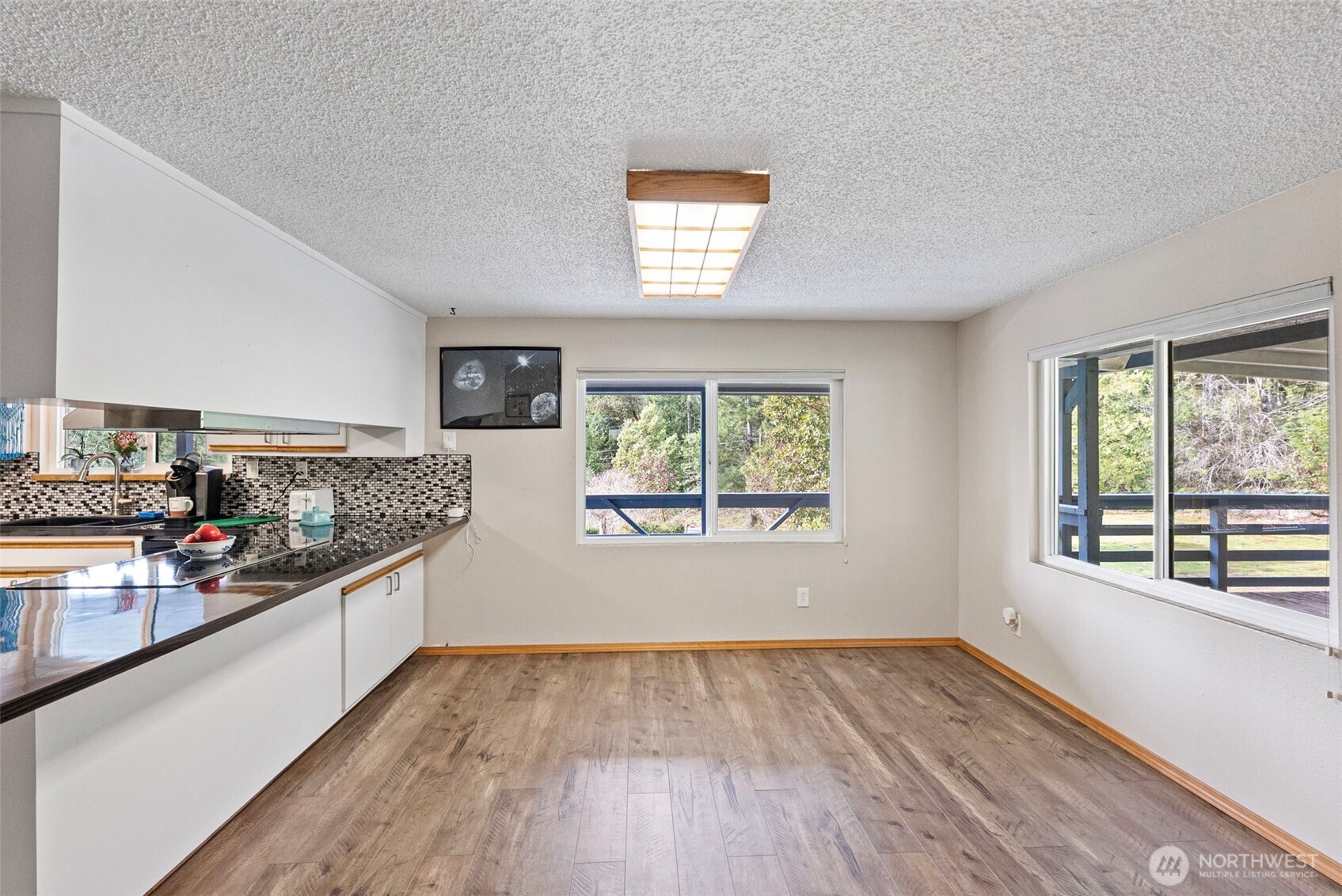 309723 Highway 101 Brinnon, WA 98320 - Photo 20 of 40 a view of a kitchen with an empty room window and wooden floor