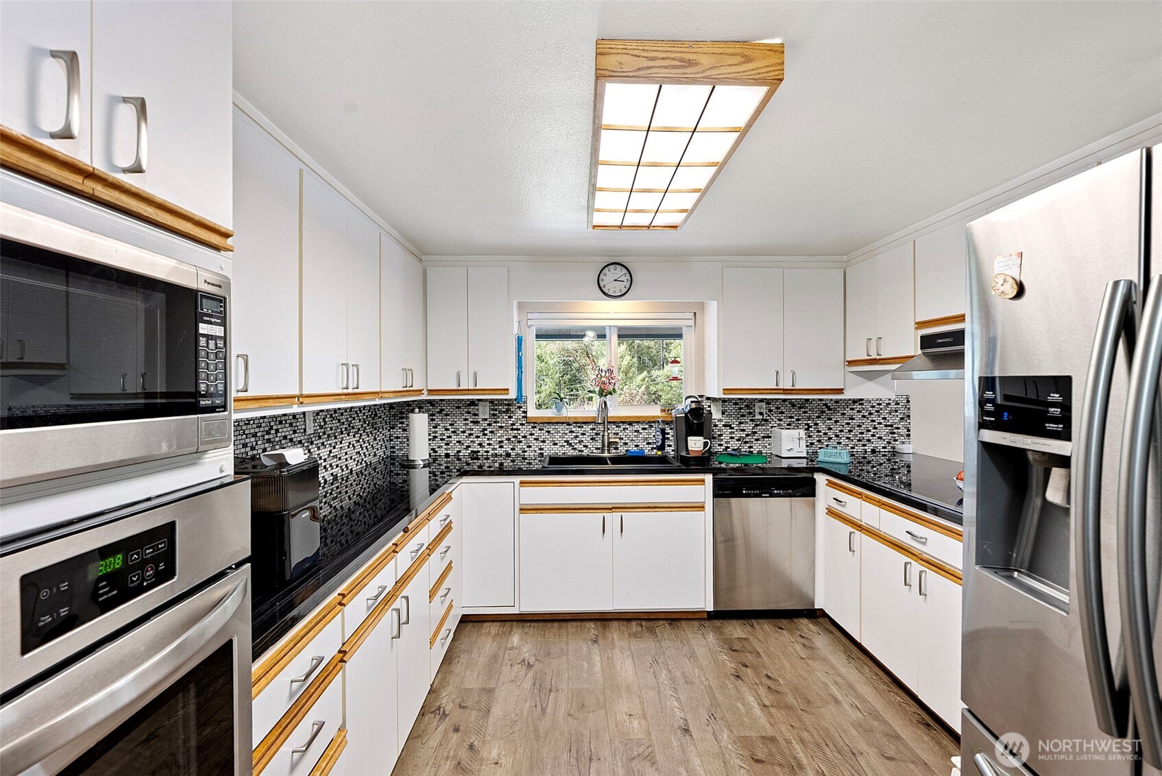 309723 Highway 101 Brinnon, WA 98320 - Photo 23 of 40 a kitchen with stainless steel appliances a sink a stove a microwave and cabinets