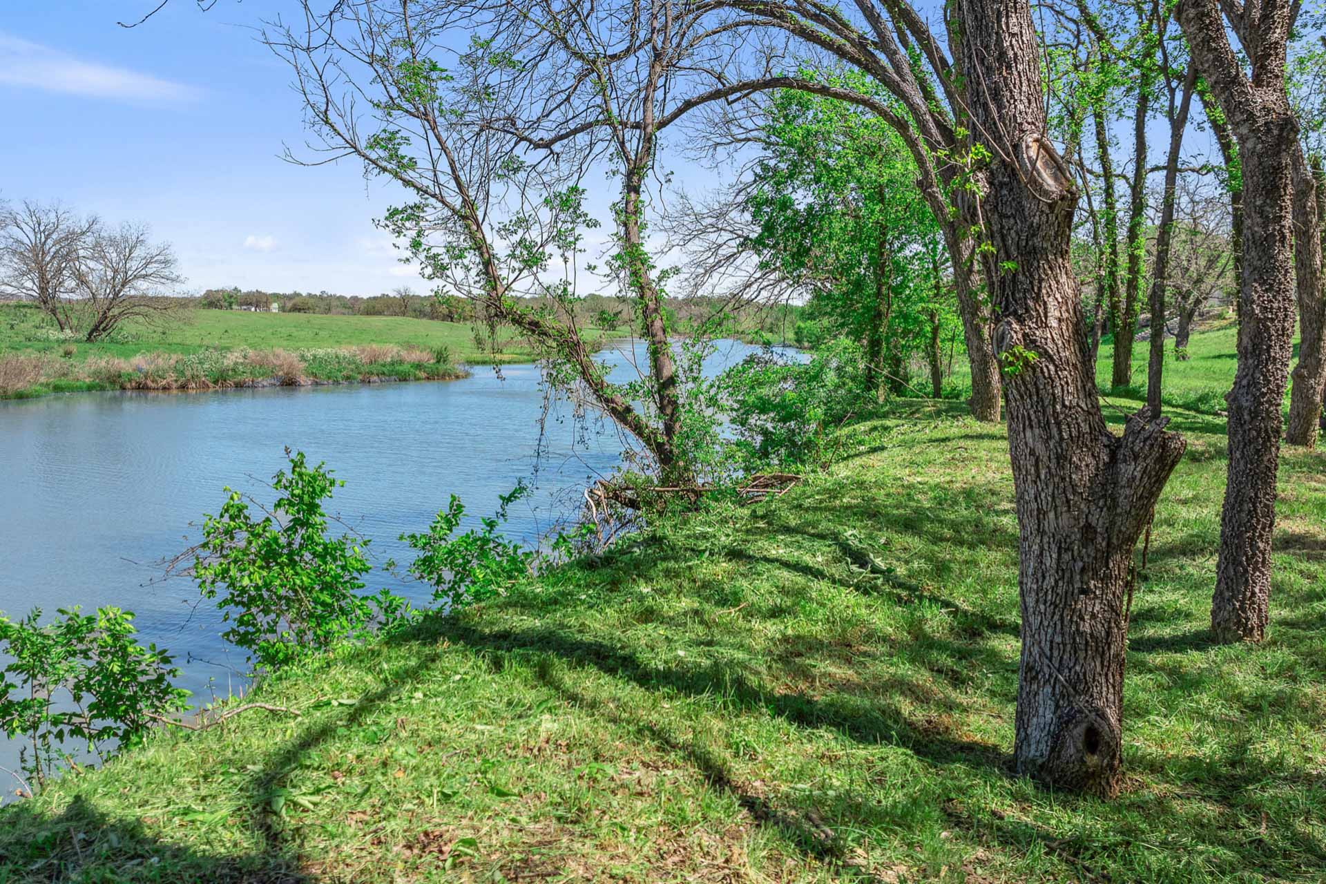 571 Ranch Road 1 Stonewall, TX 78671 - Photo 8 of 21 a view of a lake with a yard and large trees