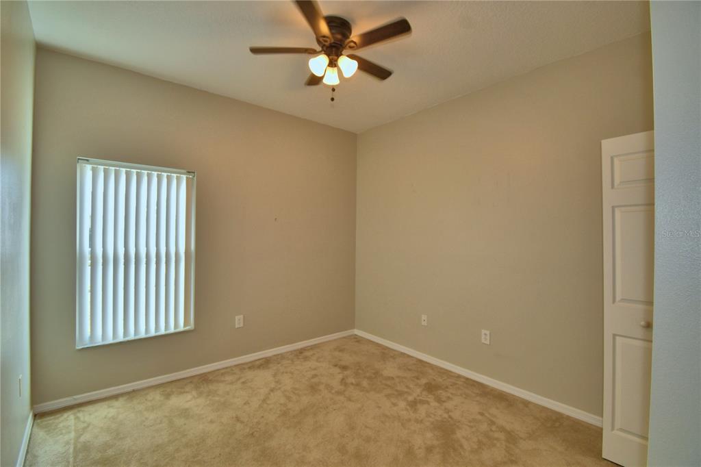 5610 Forest Ridge Drive Winter Haven, FL 33881 - Photo 19 of 70 an empty room with a window and a ceiling fan