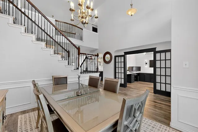 a view of a dining room with furniture a chandelier and wooden floor