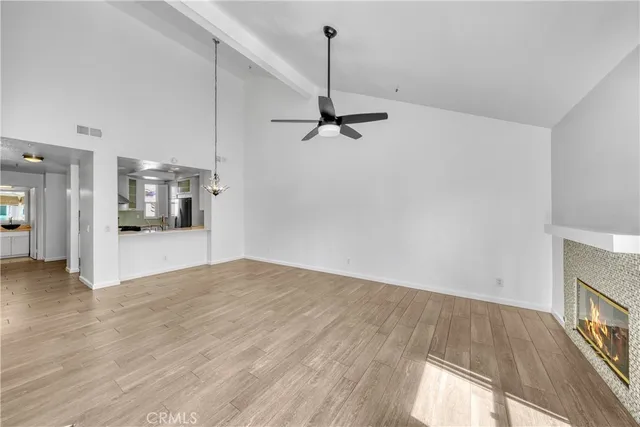 a view of a hallway with wooden floor and a bathroom