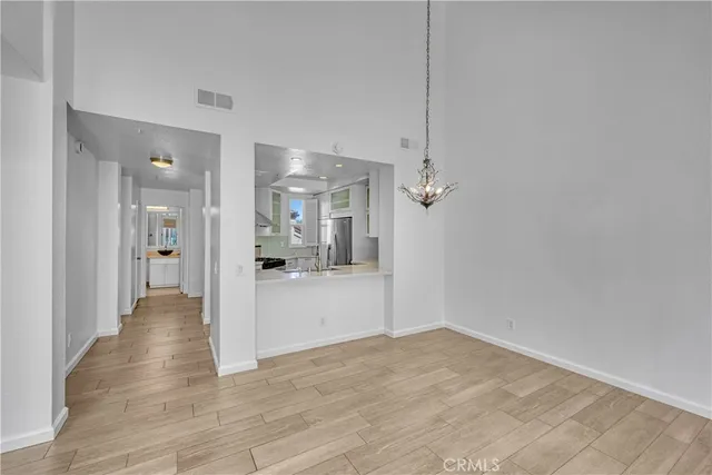 a view of a livingroom with a fireplace wooden floor and chandelier