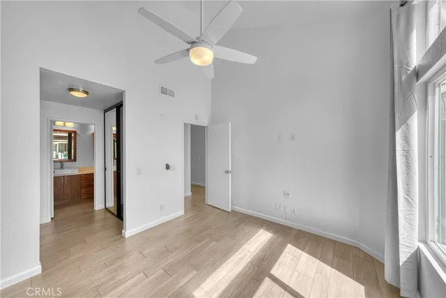 a view of a room with wooden floor and ceiling fan
