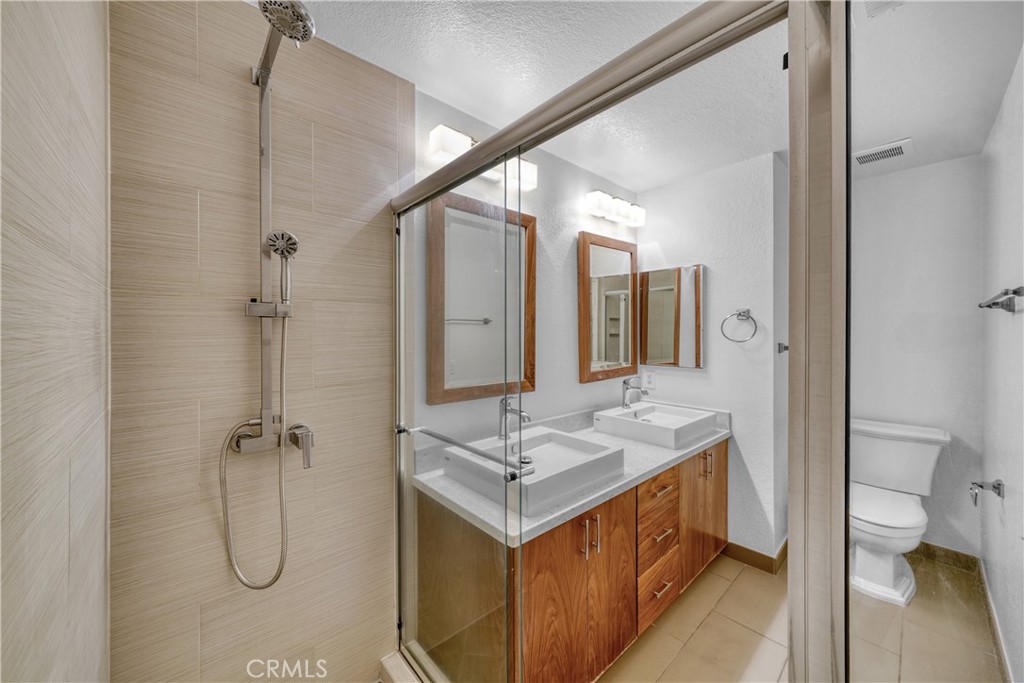 2000 Highway 1, Unit 309 Huntington Beach, CA 92648 - Photo 25 of 33 a bathroom with a granite countertop sink a toilet and shower