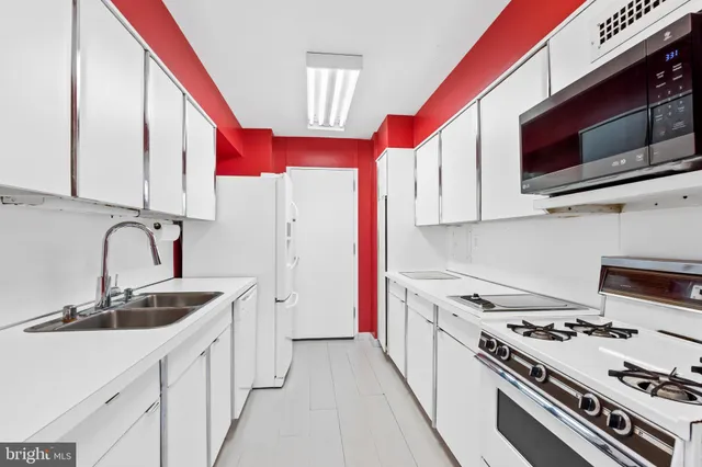 a kitchen with stainless steel appliances a sink a stove and a microwave