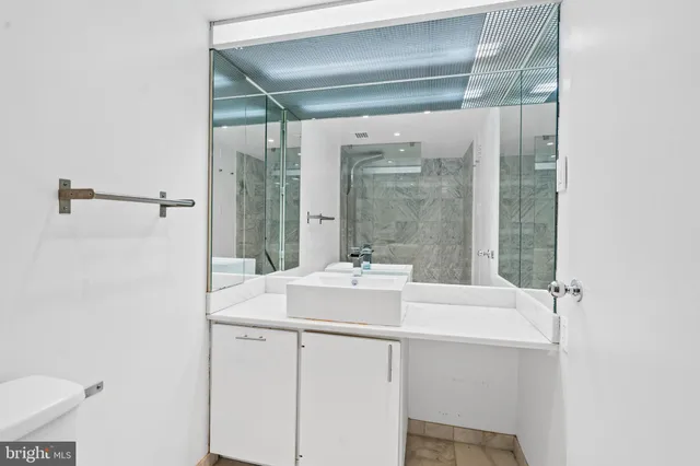 a bathroom with a sink mirror and shower
