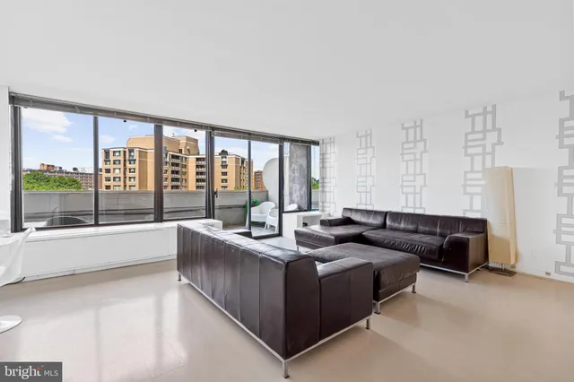 a living room with furniture and large windows