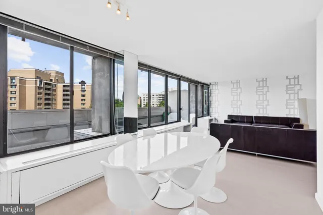 a living room with furniture and large windows