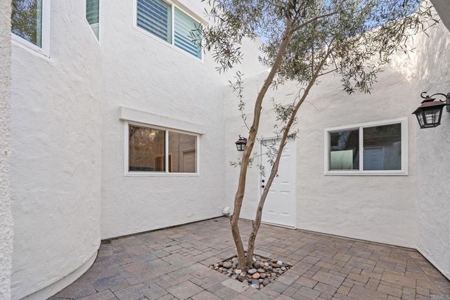 a kitchen with stainless steel appliances white cabinets and wooden floor