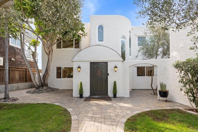 a front view of a house with a yard and trees