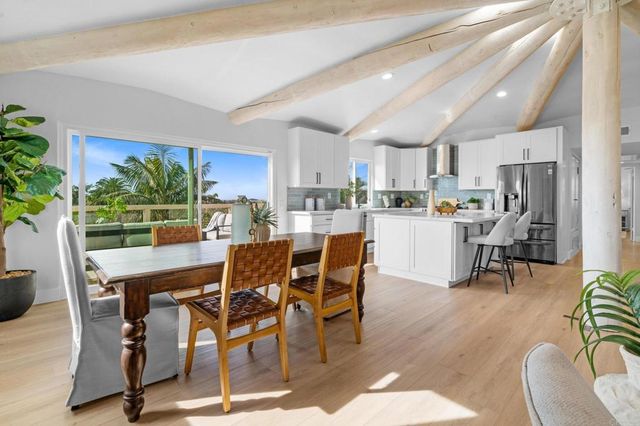 a living room with furniture a chandelier and a potted plant