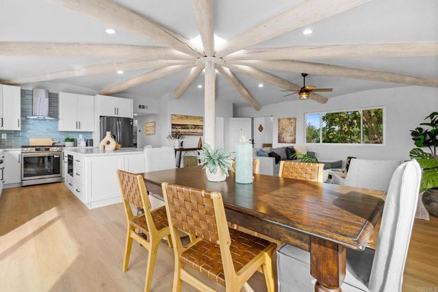 a kitchen with white cabinets chair and white appliances