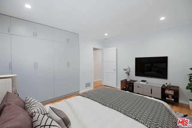 a bedroom with a bed and a flat screen tv
