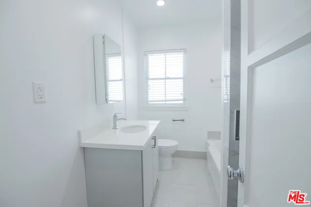a bathroom with a sink toilet and window